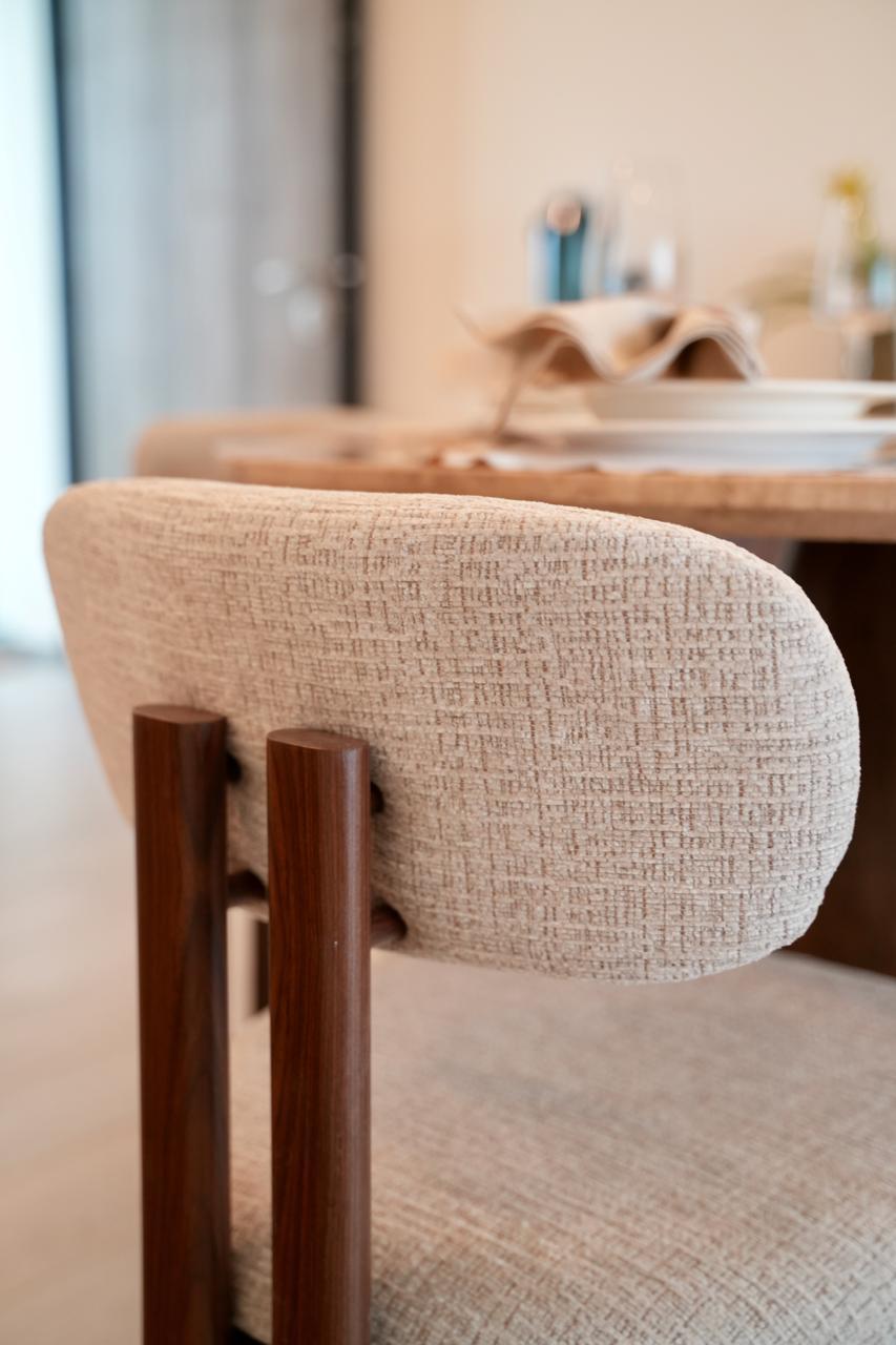 Designer dining chair detail with boucle upholstery and walnut wood frame