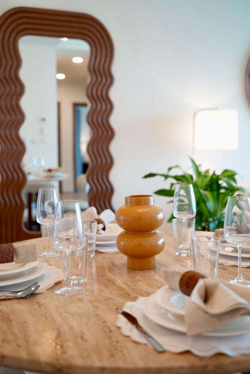 Travertine dining table close-up with terracotta vase, glassware and place settings