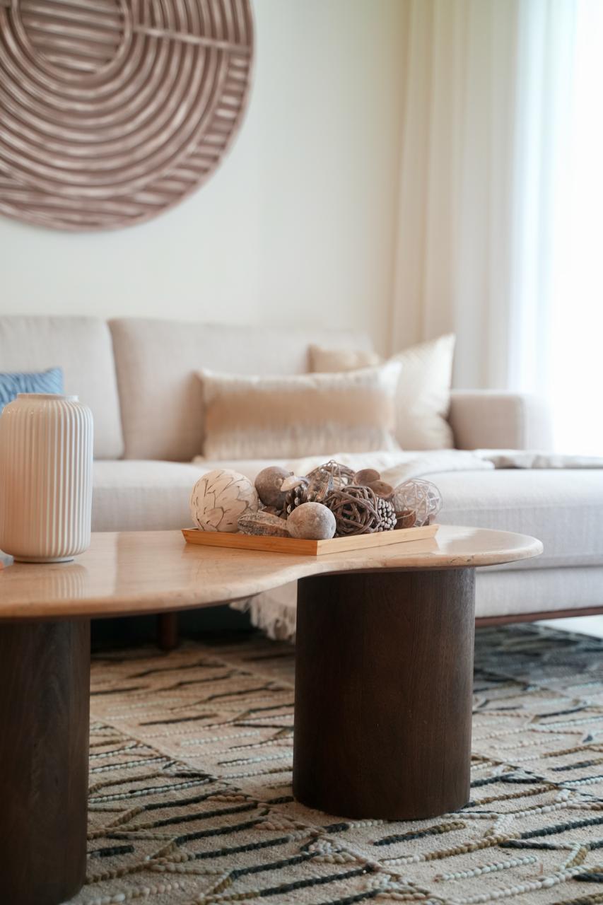 Living room detail with woven wall art and travertine coffee tables
