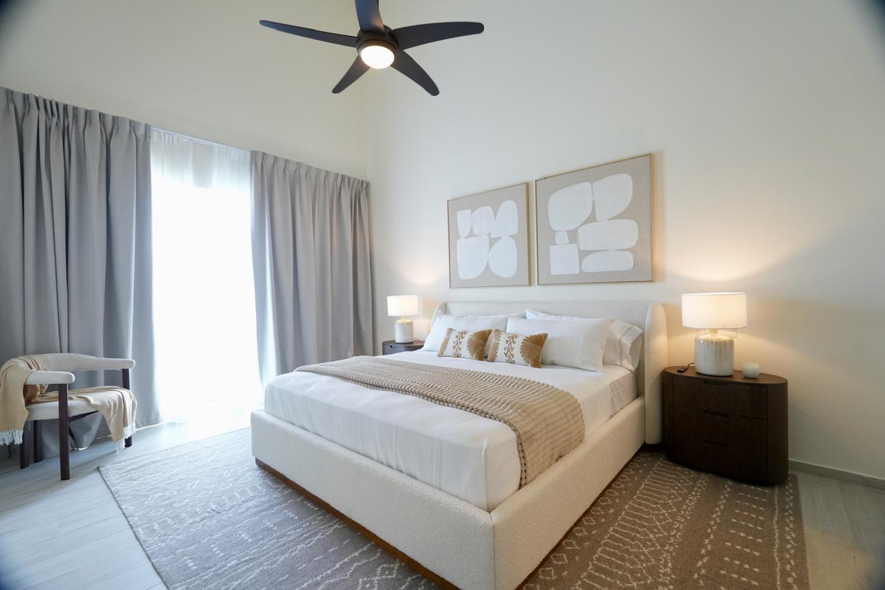 Master bedroom with king bed, high ceiling, ceiling fan and sliding doors to terrace