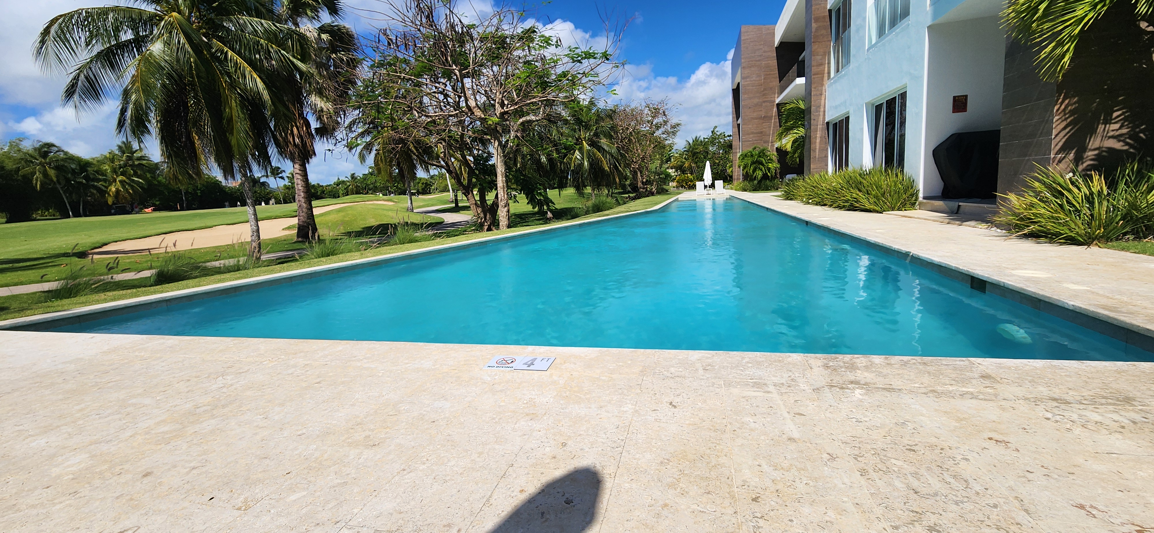 Arboleda building exterior with pool deck and golf course
