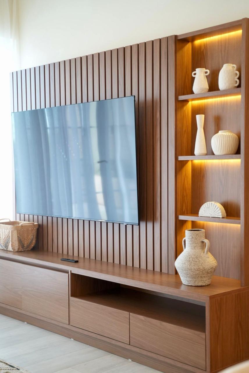 Custom walnut slatted media wall with mounted TV and LED-lit display shelves