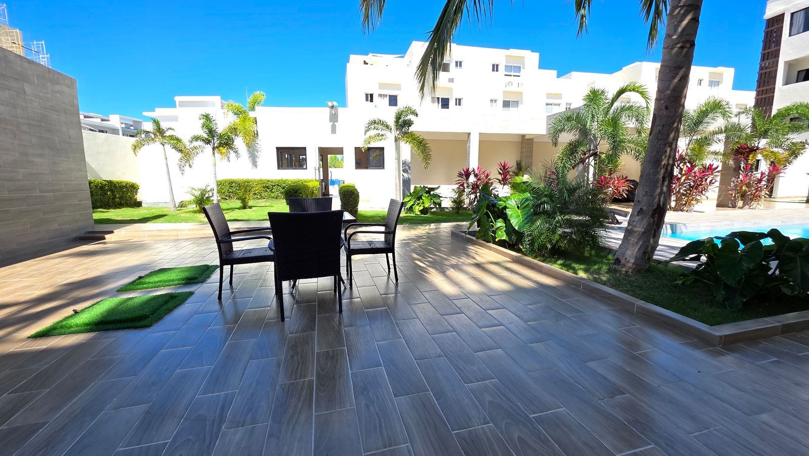 Common patio with dining area and gardens