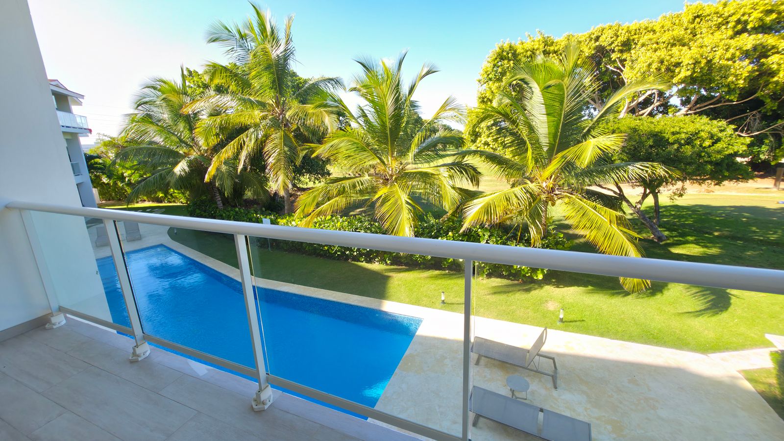 Balcony with glass railing and garden views