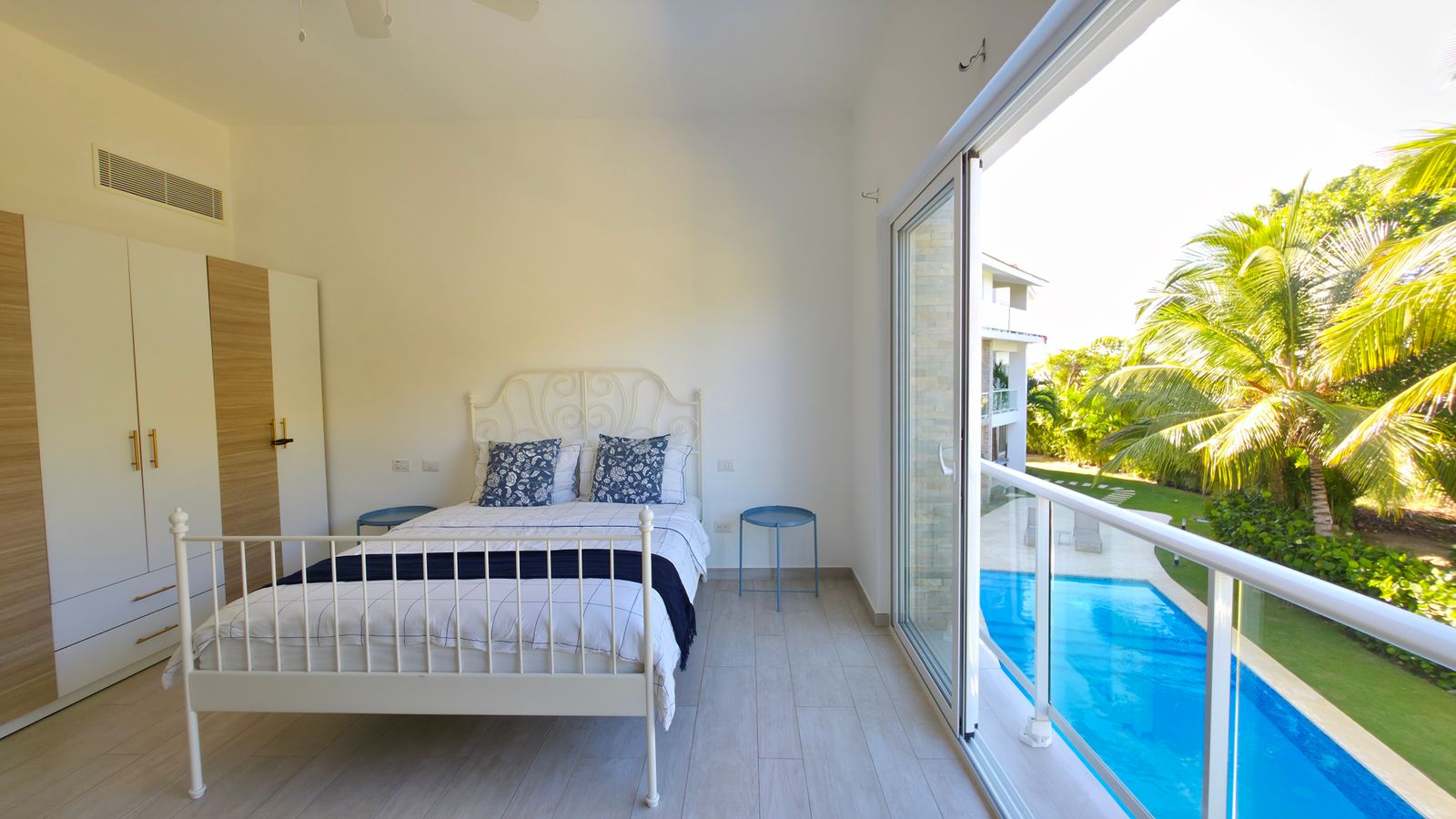 Master bedroom with balcony and pool view